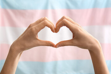 Female hands in shape of heart and transgender flag