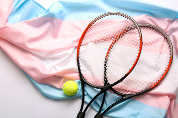 Rackets with tennis ball and transgender flag on white background