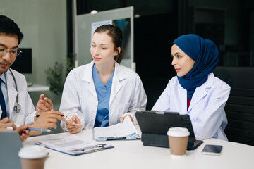 Obraz premium Medical, meeting and laptop for team in discussion, brainstorming and planning. Doctor, nurse on desk show diversity in collaboration, teamwork or workshop in hospital .