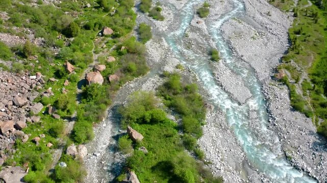 This drone footage highlights a mountain creek with a rocky bed flowing through the pristine environment of Ala Archa National Park, Kyrgyzstan.