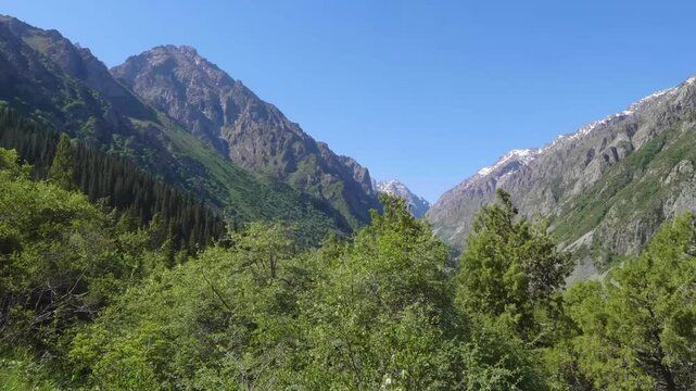 This footage captures the beautiful landscape of Ala Archa National Park, Kyrgyzstan, with sunny weather highlighting the stunning natural scenery of the area.