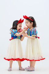Playful cute twin little girls on white background