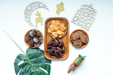 Arrangement Dates Fruit And Various Cakes On Wooden Plate With Islamic Ornaments For Eid Concept