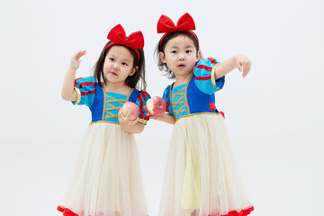 Playful cute twin little girls on white background