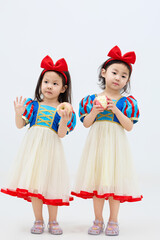 Playful cute twin little girls on white background
