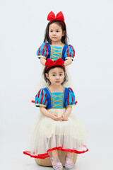 Playful cute twin little girls on white background