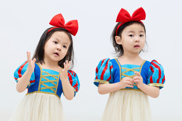 Playful cute twin little girls on white background