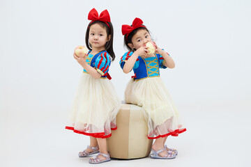Playful cute twin little girls on white background
