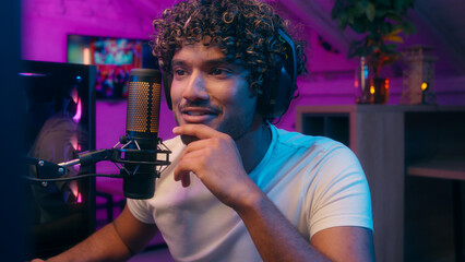 Happy excited Arabian Latino man winner guy computer addict e-sport influencer video game blogger gamer victory shout yes microphone streamer smile playing internet home win vlogger male computer neon © Yuliia