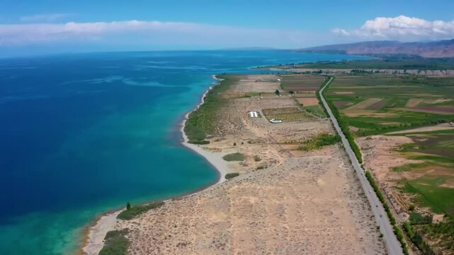 Aerial drone footage captures the vastness and beauty of Issyk-Kul Lake in Kyrgyzstan, one of the largest saline lakes in the world, surrounded by mountains.