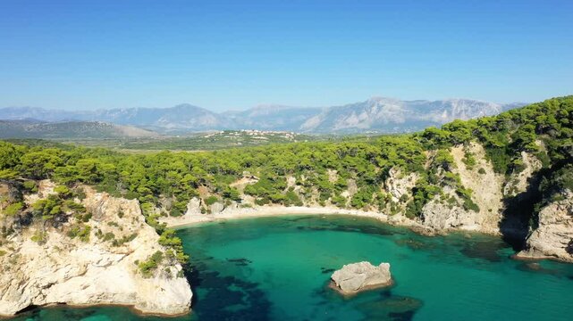 The golden sandy beach of Alonaki Fanariou nestled between green cliffs, in Europe, Greece, Epirus, towards Igoumenitsa, on the Ionian Sea, in summer, on a sunny day.&nbsp;