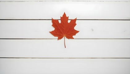 A red maple leaf displayed on a white wooden wall, highlighting Canadian pride during Canada Day festivities