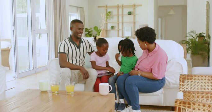 African American family sitting on white sofa in bright cozy home, sharing playful moments