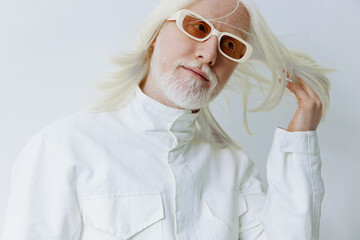 Stylish elderly man with white hair and glasses on a white background showcasing unique fashion...
