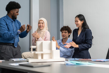 Architects engineers collaborating on building design project in modern office, diverse team of professionals female muslim architect and male engineers discussing architectural model of structure