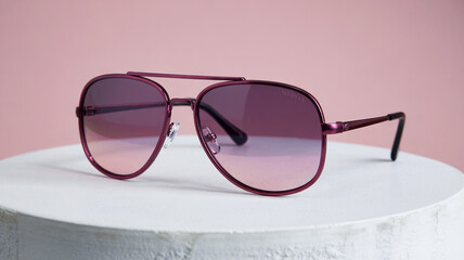 Purple Aviator Sunglasses On Display With Gradient Lenses And Pink Background