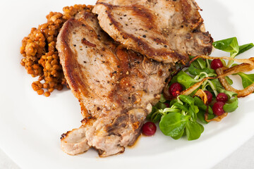 Delicious roasted pork shin served with stewed lentils, fresh greens and red currant berries