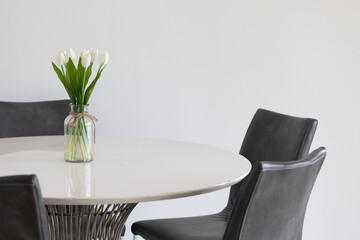 The tulips flowers in the vase add a touch of elegance to the table.