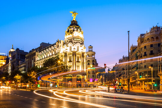 Fototapeta Street with light trails and city at night, Madrid, Spain