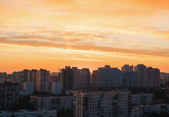 Fototapeta premium Vibrant city skyline during sunset with colorful clouds reflecting over urban buildings