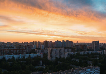 Naklejka premium Sunset over urban landscape with vibrant colors illuminating buildings in city skyline