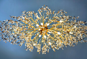 Close up of a golden chandelier photographed from bottom view. Gold chandelier forming organic...