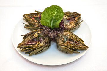 Grilled artichokes, grilled artichoke halves with sauces isolated on white background