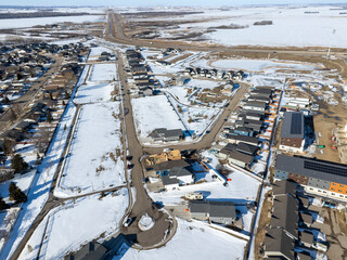 Snowy residential area with houses and a street