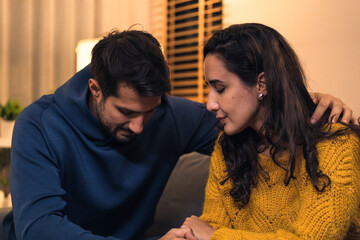 Hispanic Emotional couple comforting each other at night during a sad moment in their married relationship