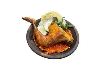 Ayam penyet is Indonesian traditional Fried Chicken served with sambal terasi chili sauce, fresh cabbage, cucumber slice, and basil leaves, served at clay plate, isolated on white 