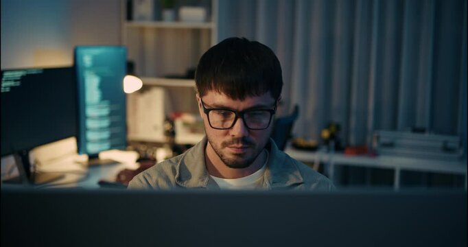 Focused Developer Working Late at Night in Tech Office.