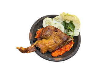 Bebek penyet is Indonesian traditional Fried duck served with sambal terasi chili sauce, fresh cabbage, cucumber slice, and basil leaves, served at clay plate or traditional mortar, isolated on white 