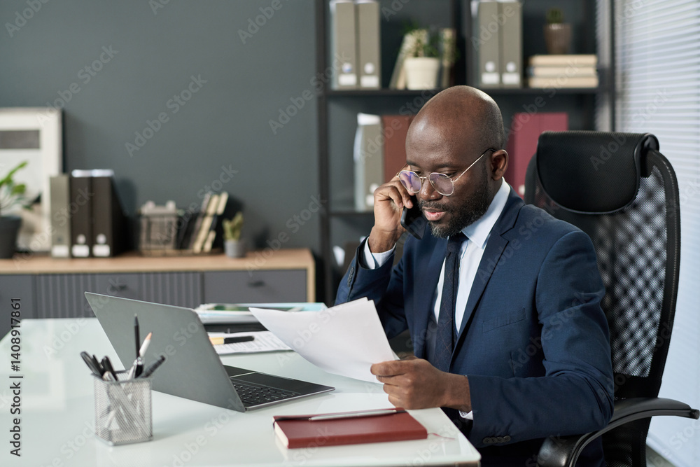 Poster african american businessman having conversation on mobile phone while working at his workplace with