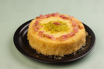 Kunafa is Arabic Traditional Desserts in a Plate With Pistachio and Roses Petal.