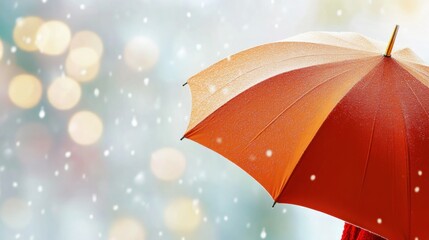 Bright orange umbrella protects against falling snowflakes in a winter setting with soft, glowing lights creating a magical atmosphere