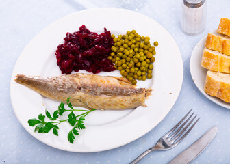 Fillet appetizing cold smoked mackerel with canned peas and grated boiled beets. Decorated with a...