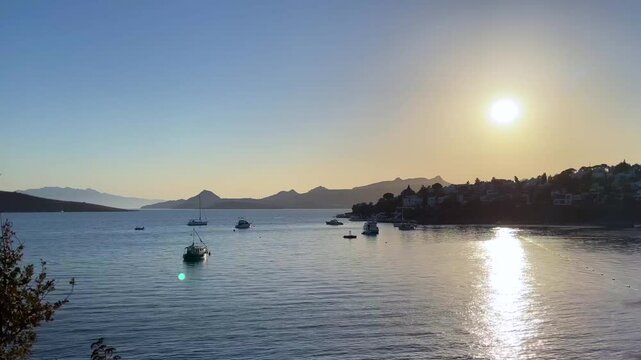 Beautiful coast with mountains, boats and yachts. Blue sea sparkling at sunset.