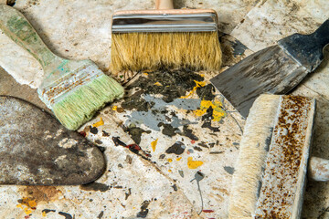Old brushes and spatulas with paint stains. Painting and repair tools.