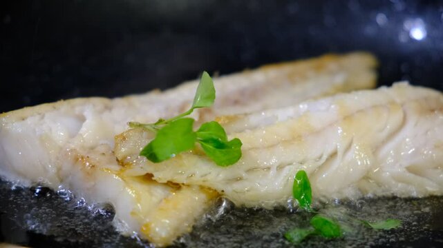 Cooking Indoors pan grilled seasoned Cod fillets on Stovetop, iron cast pan, close up boiled oil, deep fried. White meat