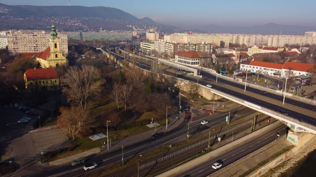 Aerial pullback reveals dense Budapest traffic flowing through structured roads and bridges