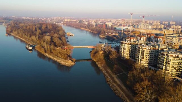 Wide overview of Foka-&ouml;b&ouml;l area with buildings reflecting golden hour light over calm water