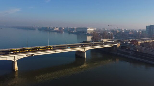 Long bridge crosses Danube with moving traffic as Budapest fades into sunset horizon glow