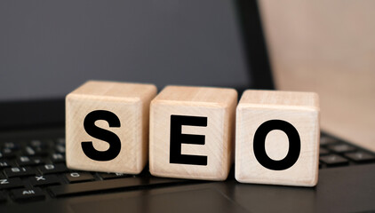 SEO text on wooden cubes on black keyboard