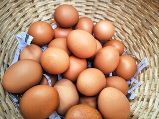 Fresh brown and white chicken eggs in a natural basket, a healthy breakfast ingredient from the farm