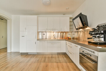 A sleek and modern kitchen featuring white cabinetry, stainless steel appliances, and a minimalist...