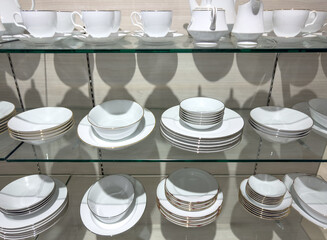 A shelf full of white plates and bowls