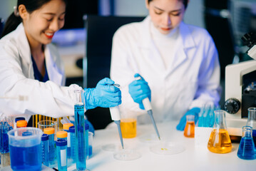 Two female biotechnologists testing new chemical substances in a laboratory.
