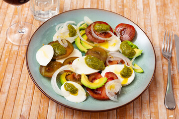 Appetizing caprese salad with avocado served on plate