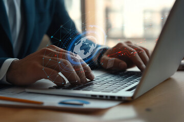 Business professional working on laptop with digital interface and globe symbolizing global connectivity and technology trends in modern workplace