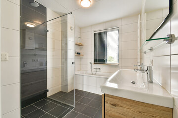Sleek and contemporary bathroom design featuring a glass shower, bathtub, and stylish sink. The space is bright with minimalistic decor and natural light.